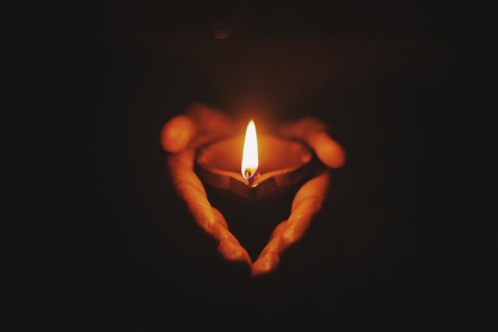 person holding lighted oil lamp